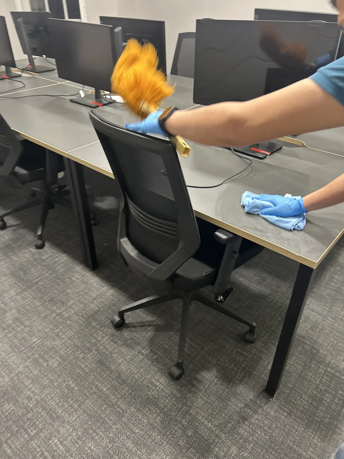 A Cleanfinity operative detail-cleaning desks, Great Portland Street, London