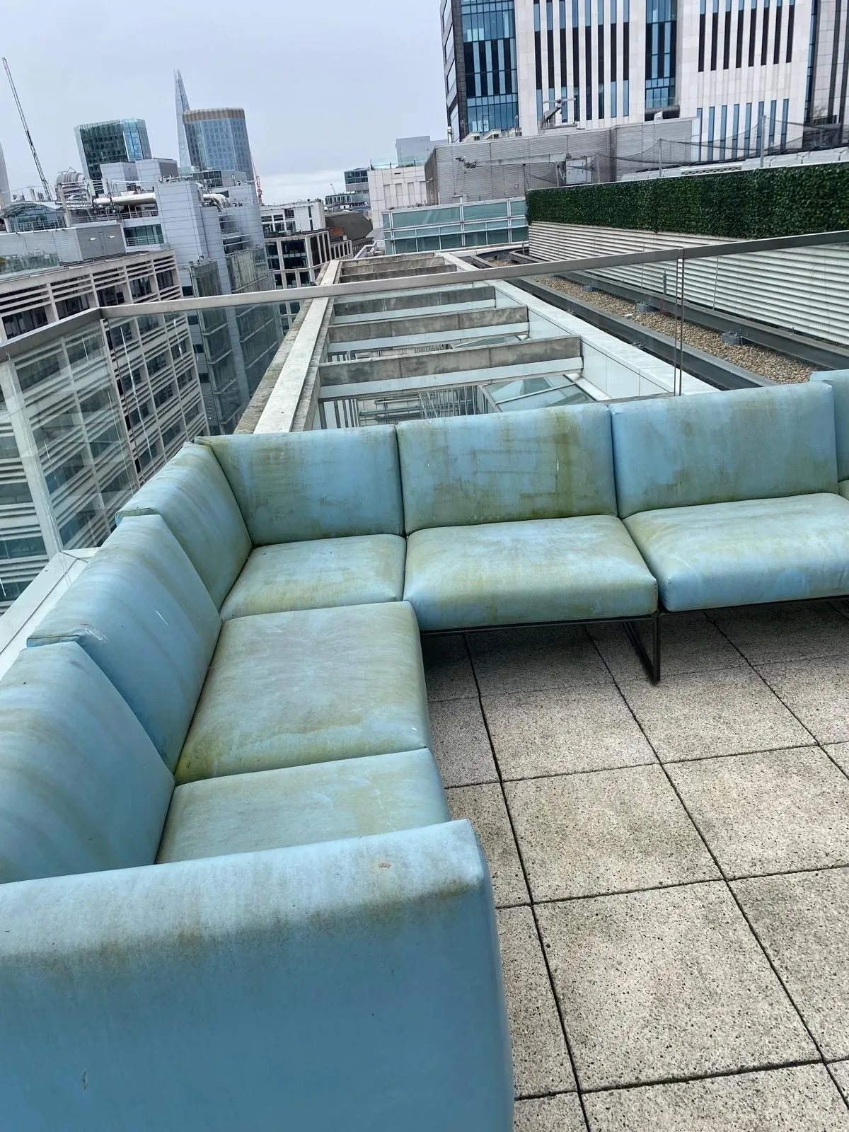 The corner of an office terrace sofa at Moorgate before cleaning, with algae staining across the seat