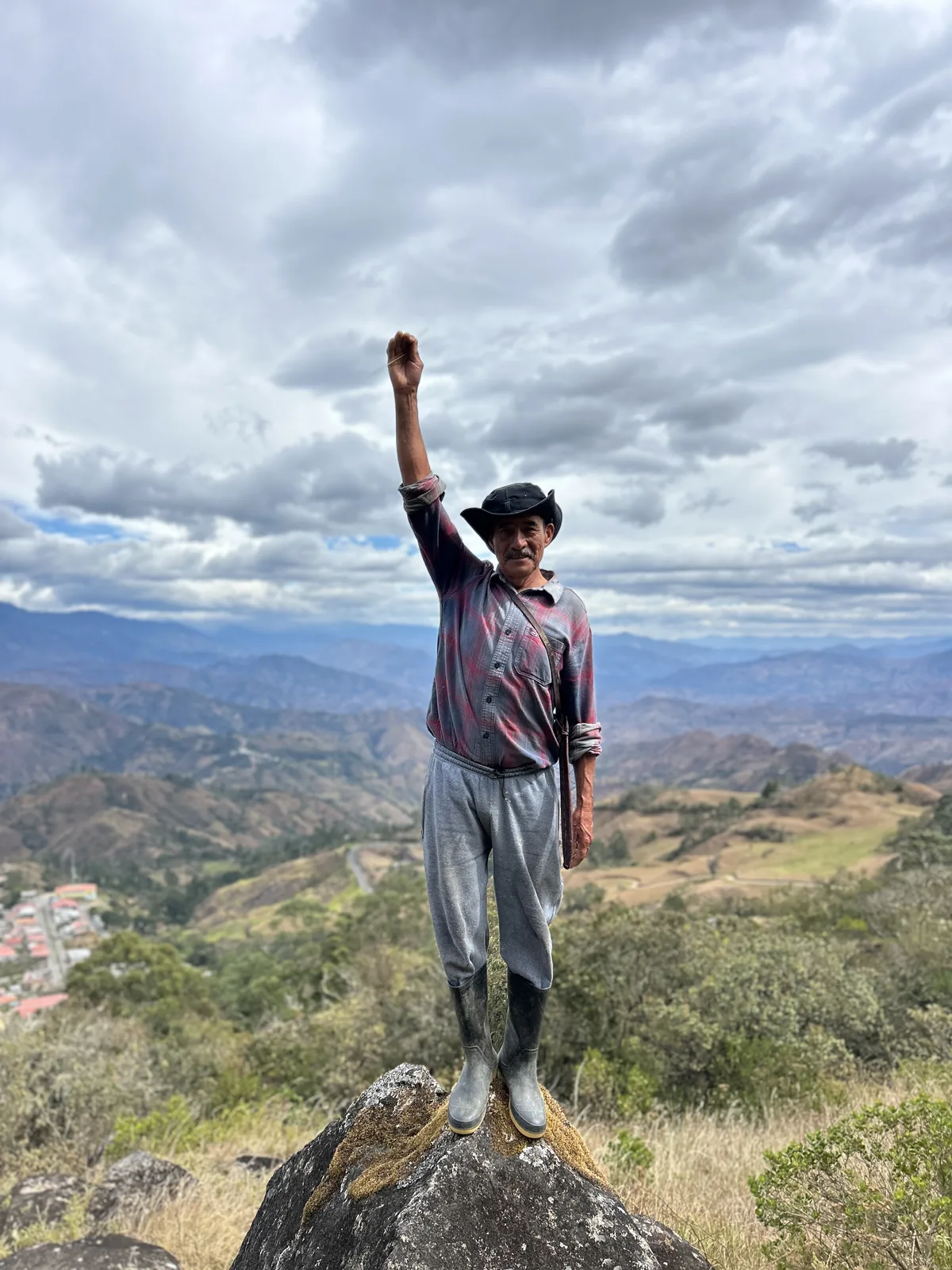 A coffee farmer standing above the valley he farms, Loja province, Ecuador
